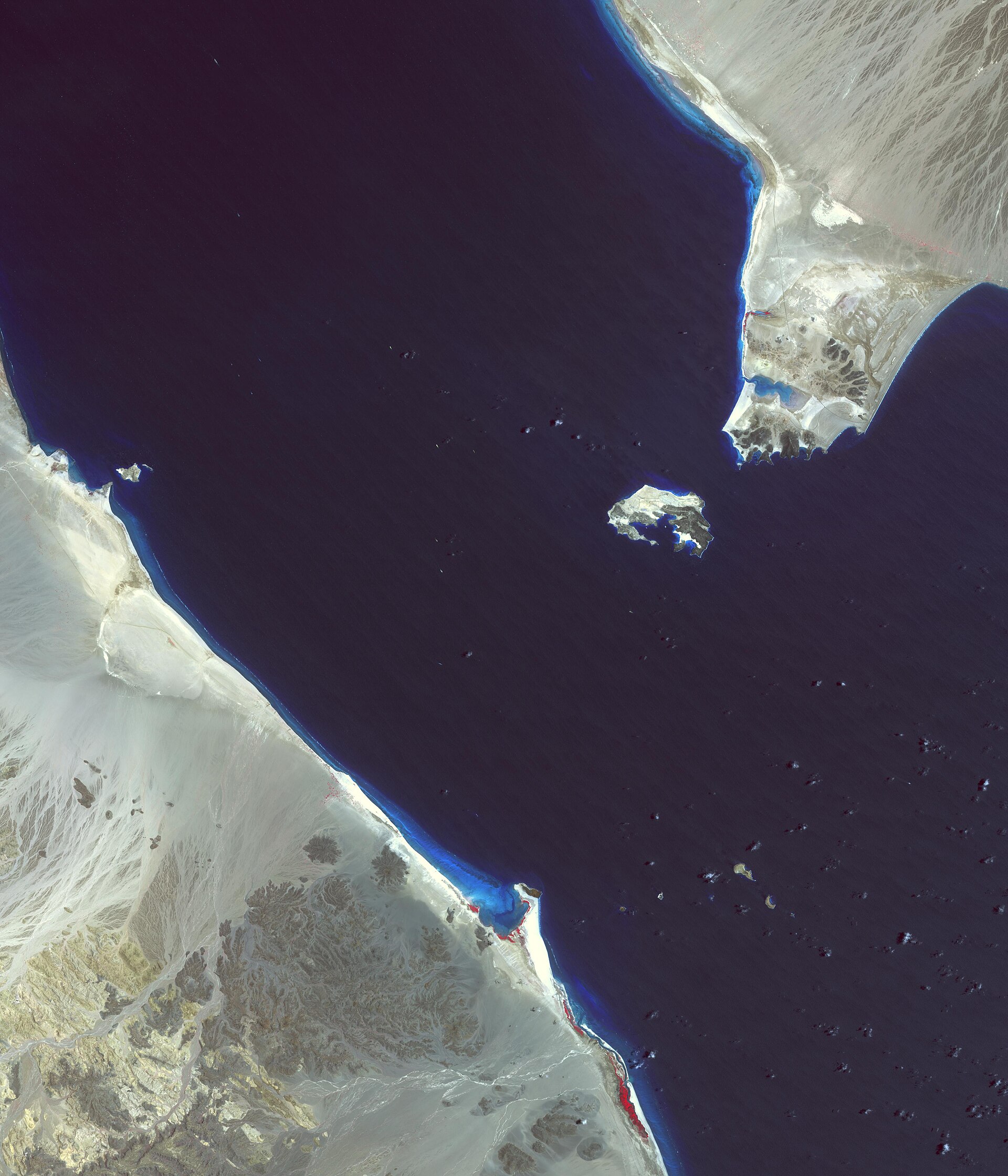 Vista satelital de un estrecho marítimo entre costas desérticas e islas.