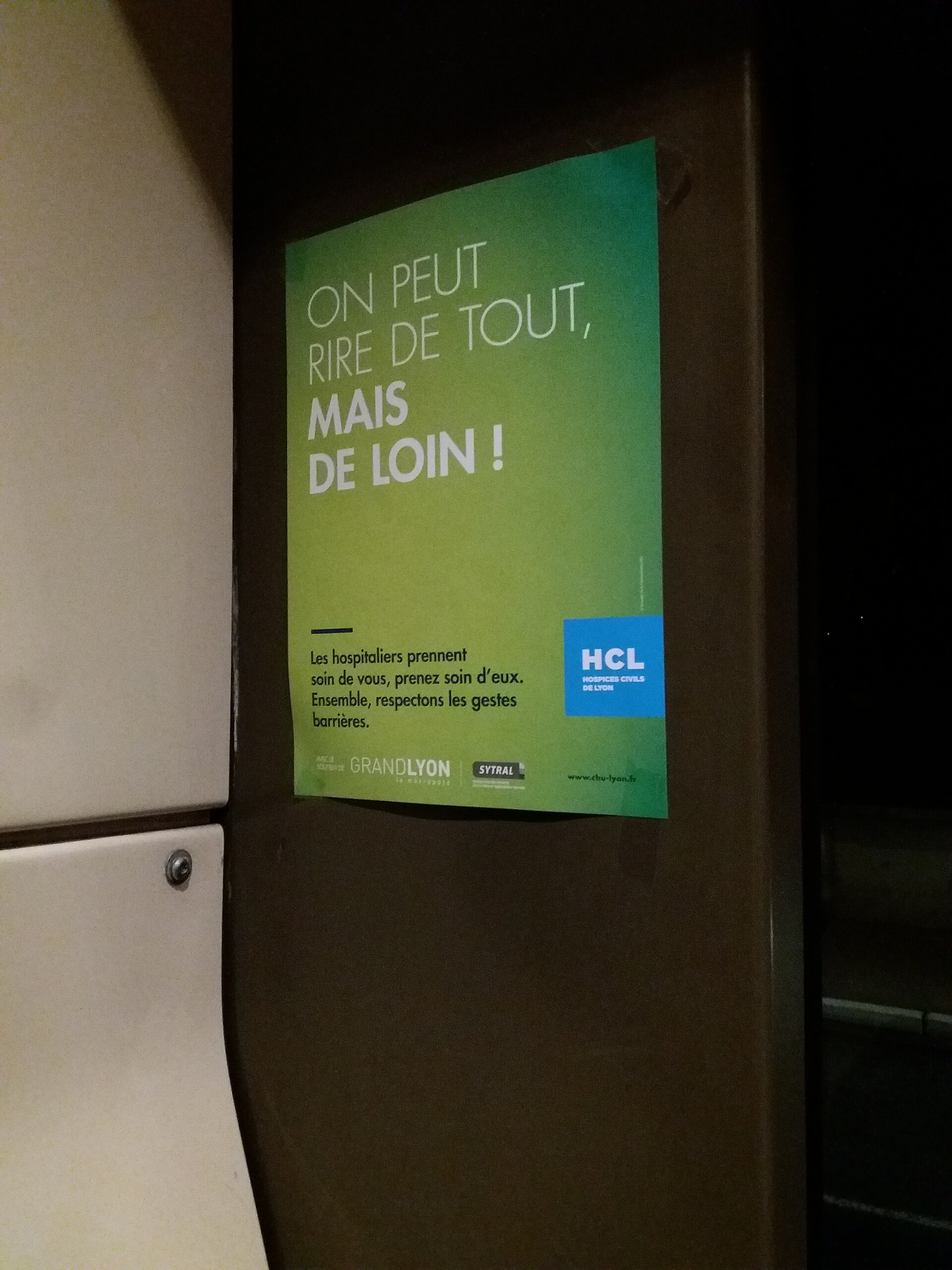 Un cartel verde muestra un mensaje sobre respetar las medidas de barrera y el logotipo HCL.
