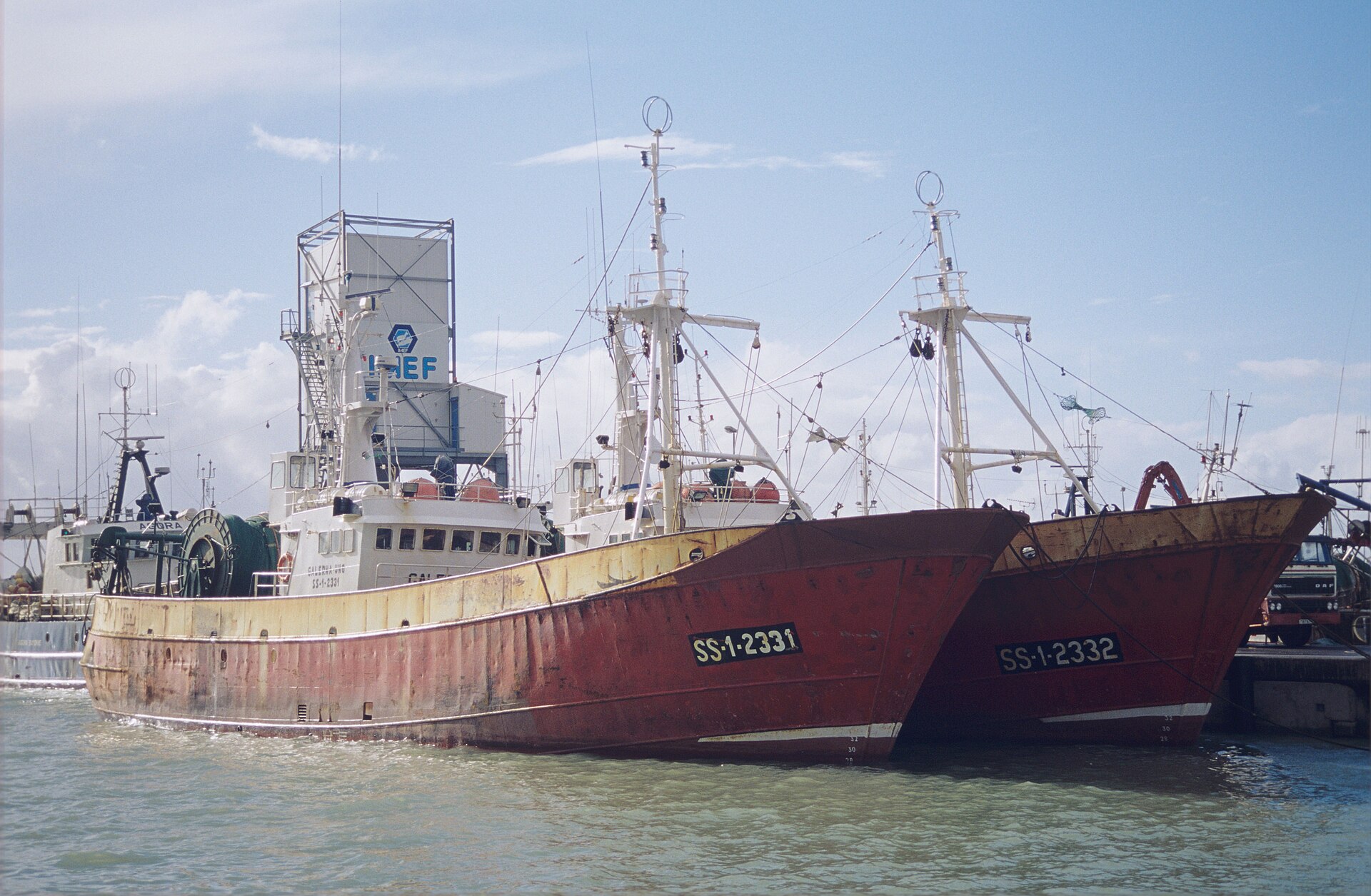 Dos grandes barcos de pesca navegan juntos.