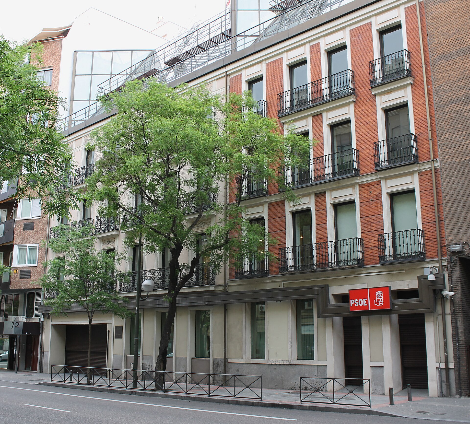Fachada de un edificio con un rótulo rojo que dice PSOE sobre la entrada.