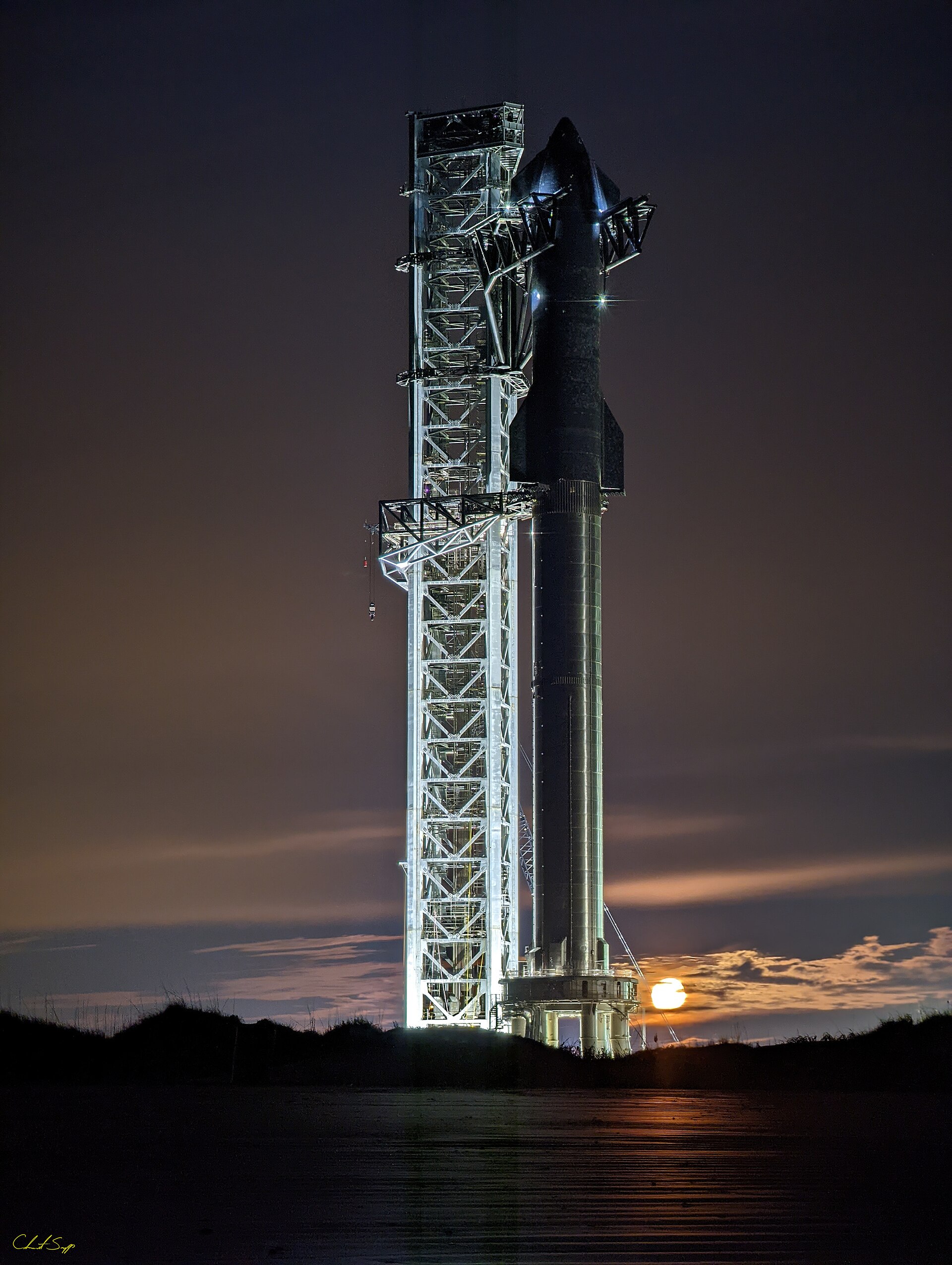Un vehículo espacial junto a una torre de lanzamiento, con un disco brillante bajo el horizonte.