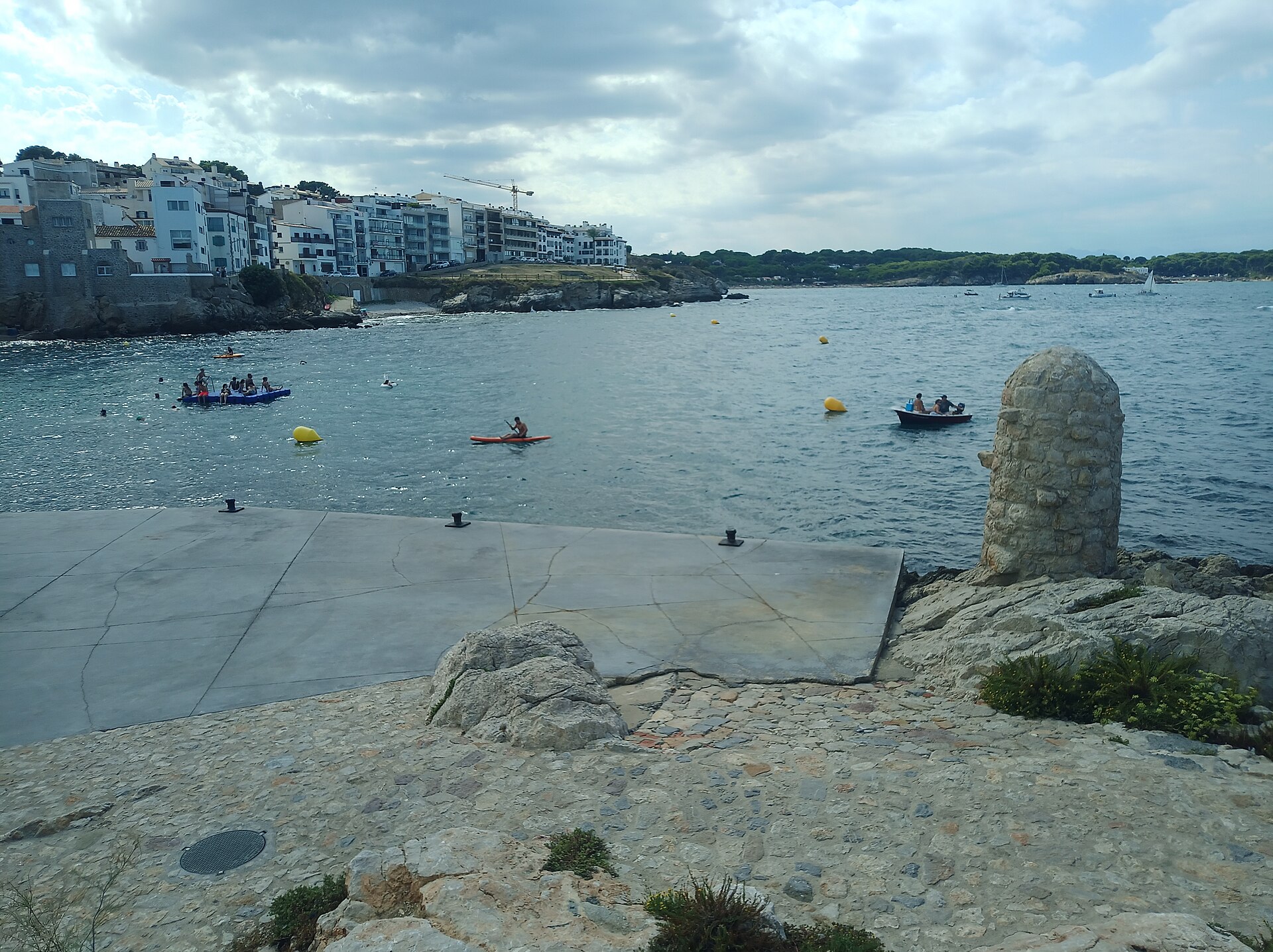 Vista de edificios residenciales junto a una bahía, con varias embarcaciones en el agua.