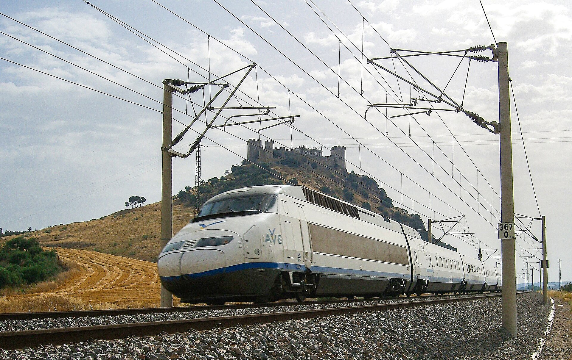 Un tren de alta velocidad circula por una vía electrificada.