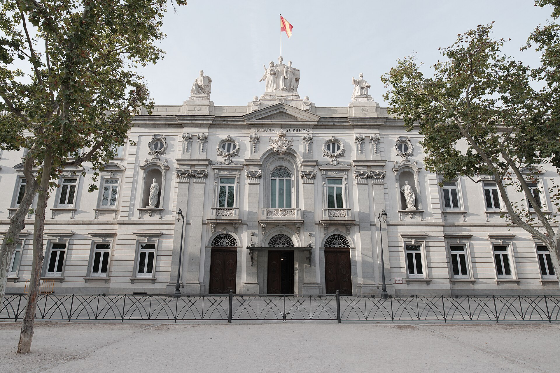 Fachada de un edificio institucional, con una bandera sobre la entrada principal.