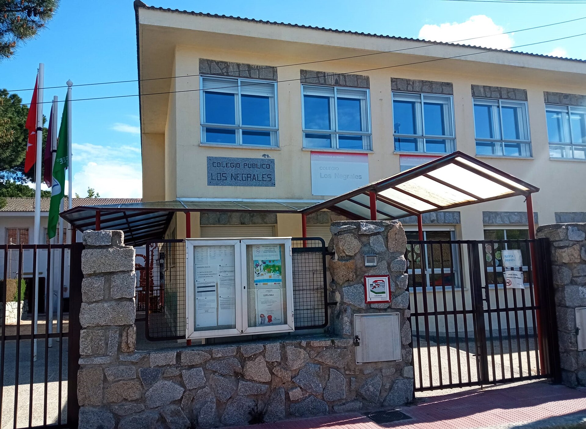 Fachada de un centro escolar tras una verja cerrada.