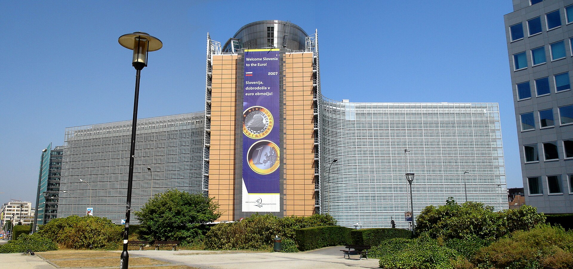 Edificio institucional con una gran pancarta sobre la entrada de Eslovenia en el euro.