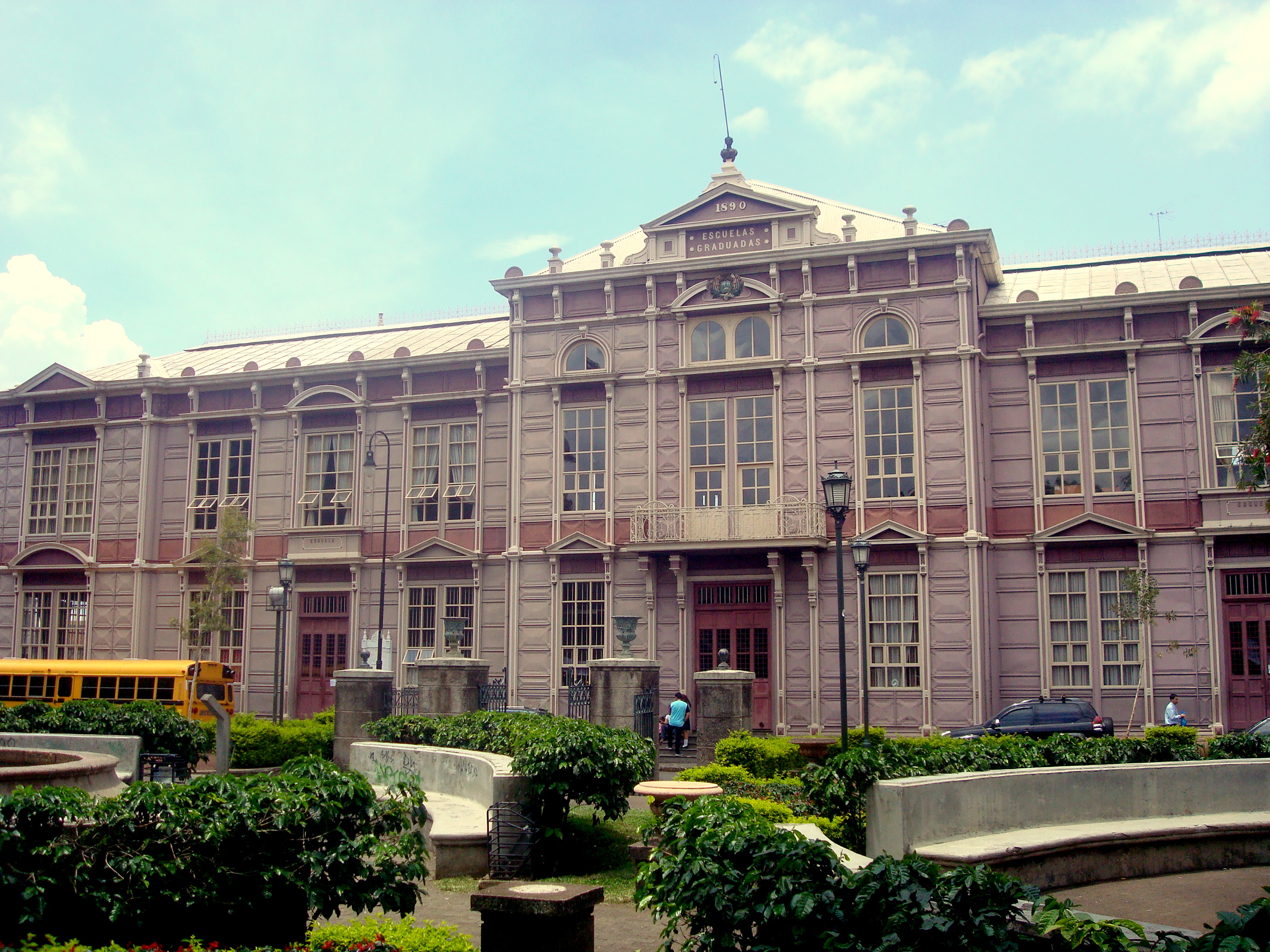 Fachada de un edificio histórico con la inscripción «ESCUELAS GRADUADAS», frente a una zona ajardinada.