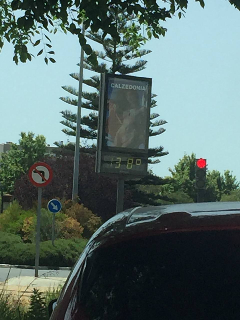 Un panel digital muestra 33,8 grados junto a una intersección urbana.