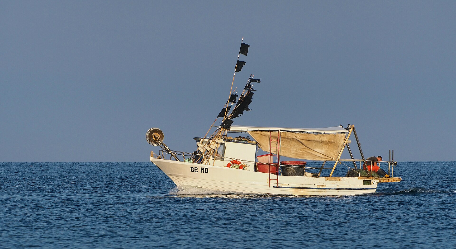 Una embarcación pesquera navega sobre el mar.