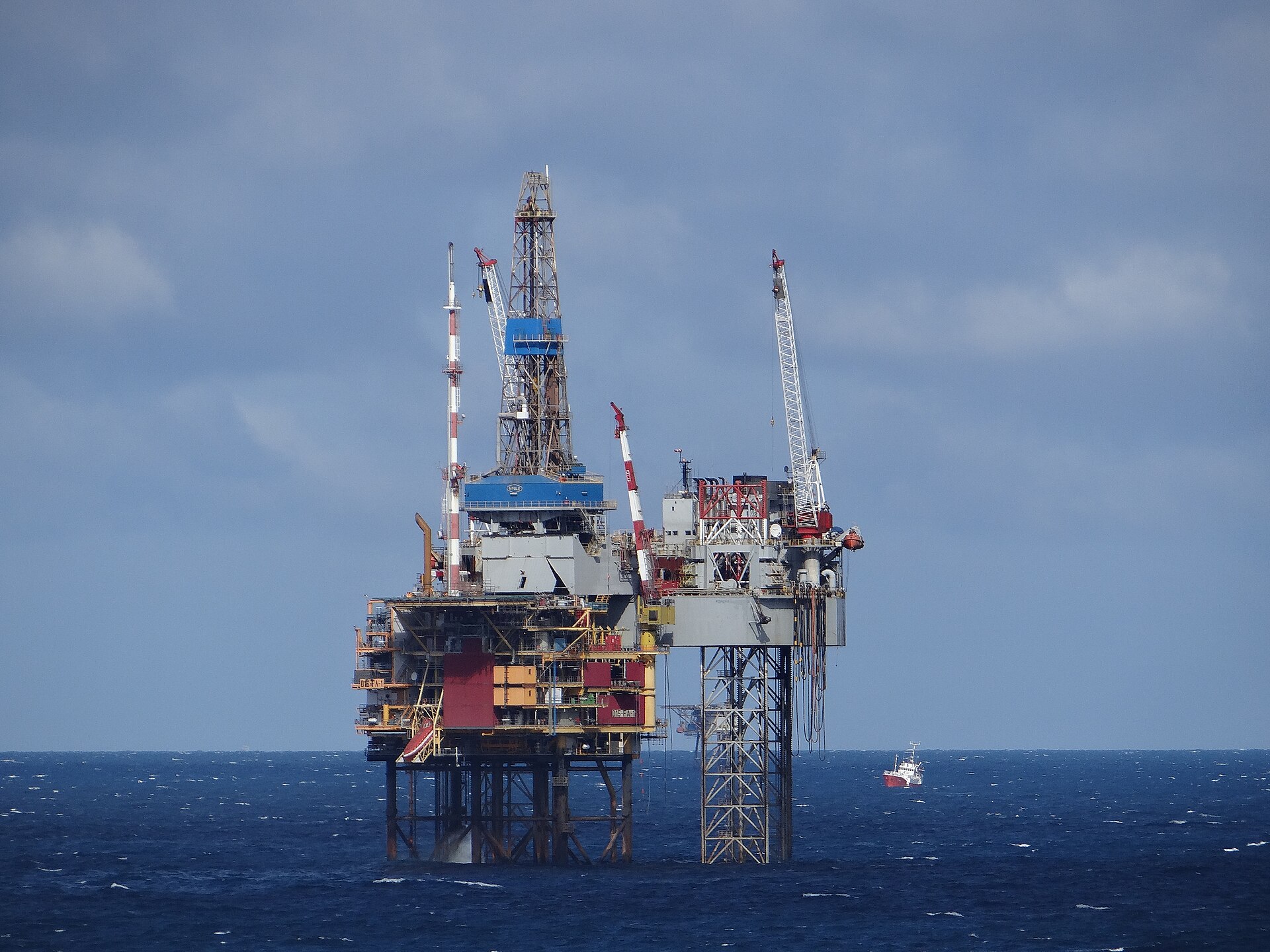 Una plataforma petrolífera sobre el mar, con grúas y estructuras metálicas.