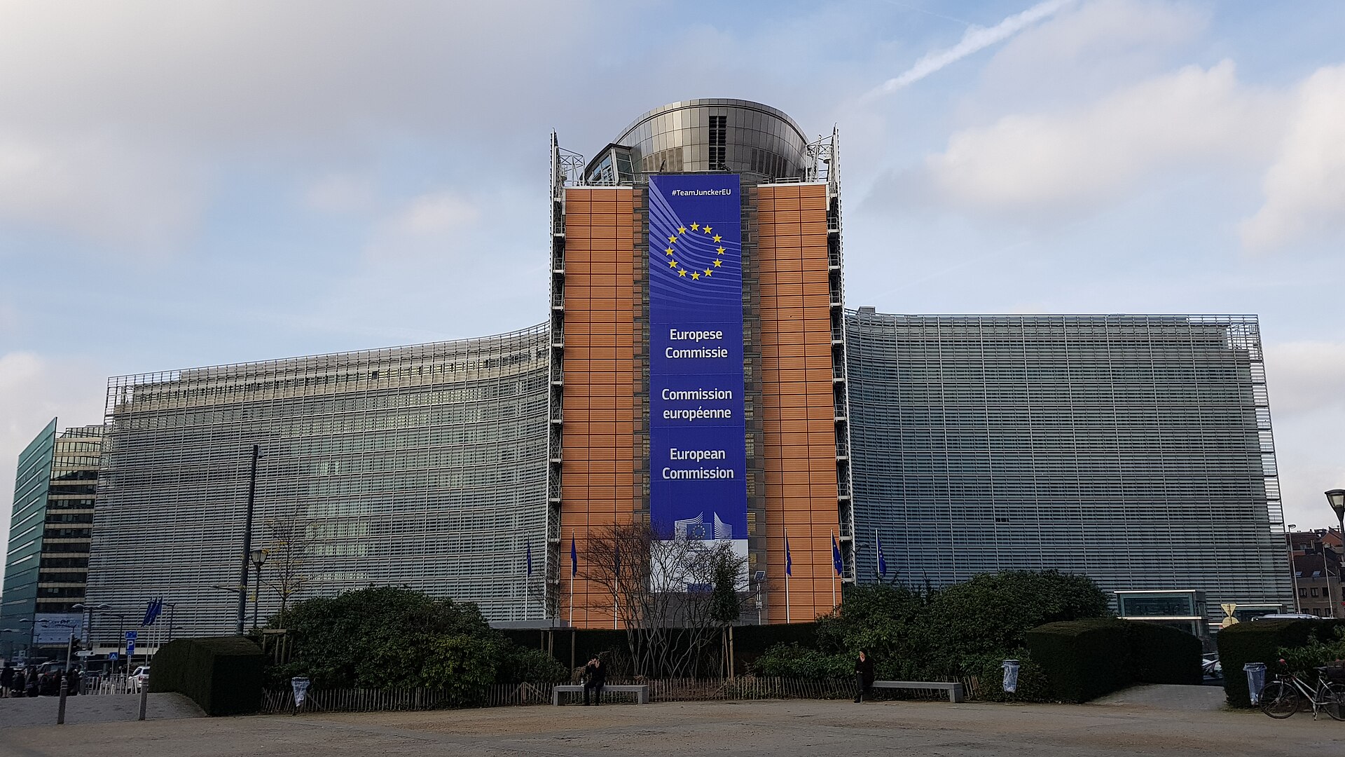 Fachada de un edificio con una pancarta de la Comisión Europea y banderas europeas.