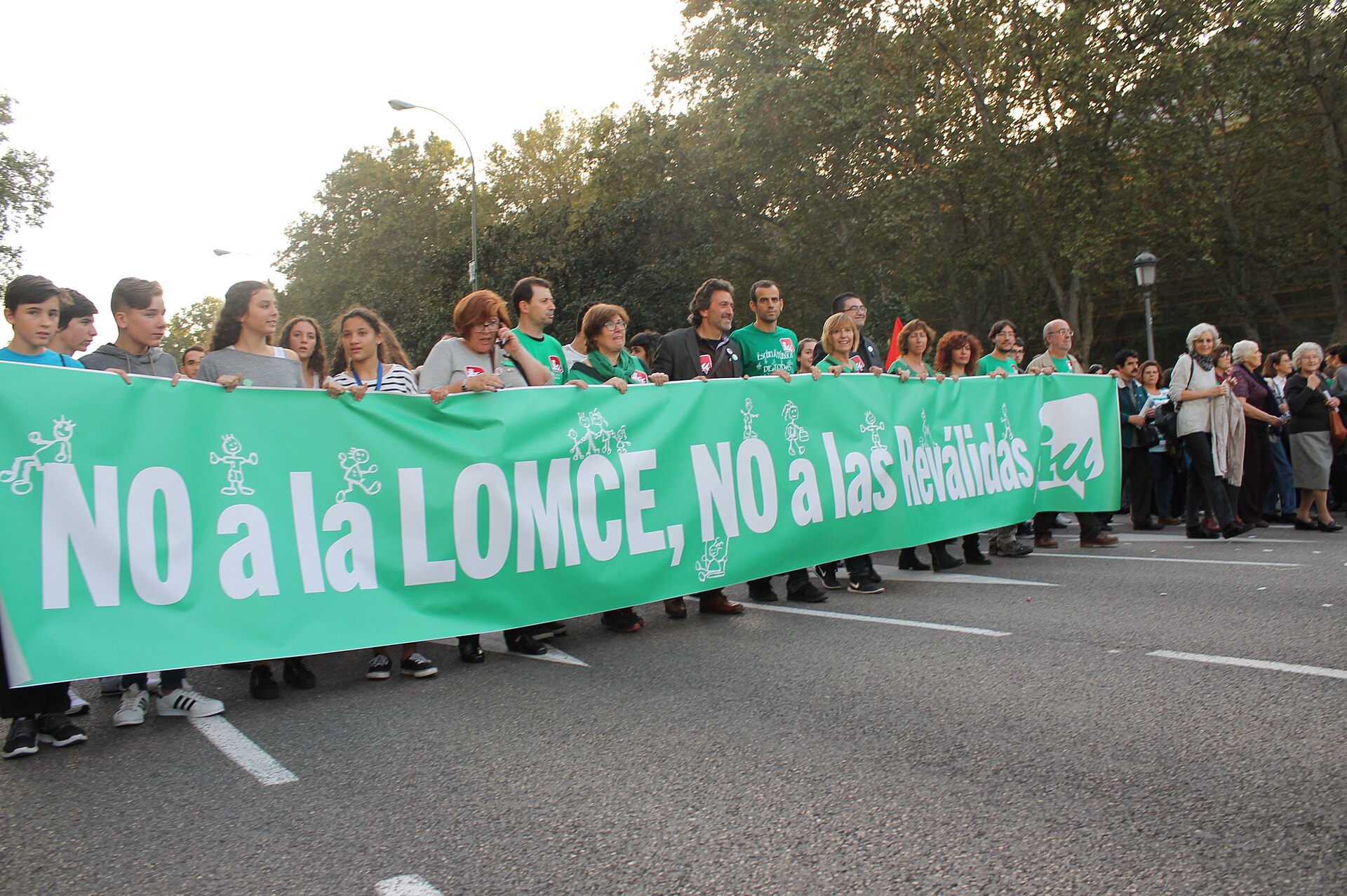 Manifestantes avanzan tras una pancarta verde con el lema «No a la LOMCE, no a las reválidas».