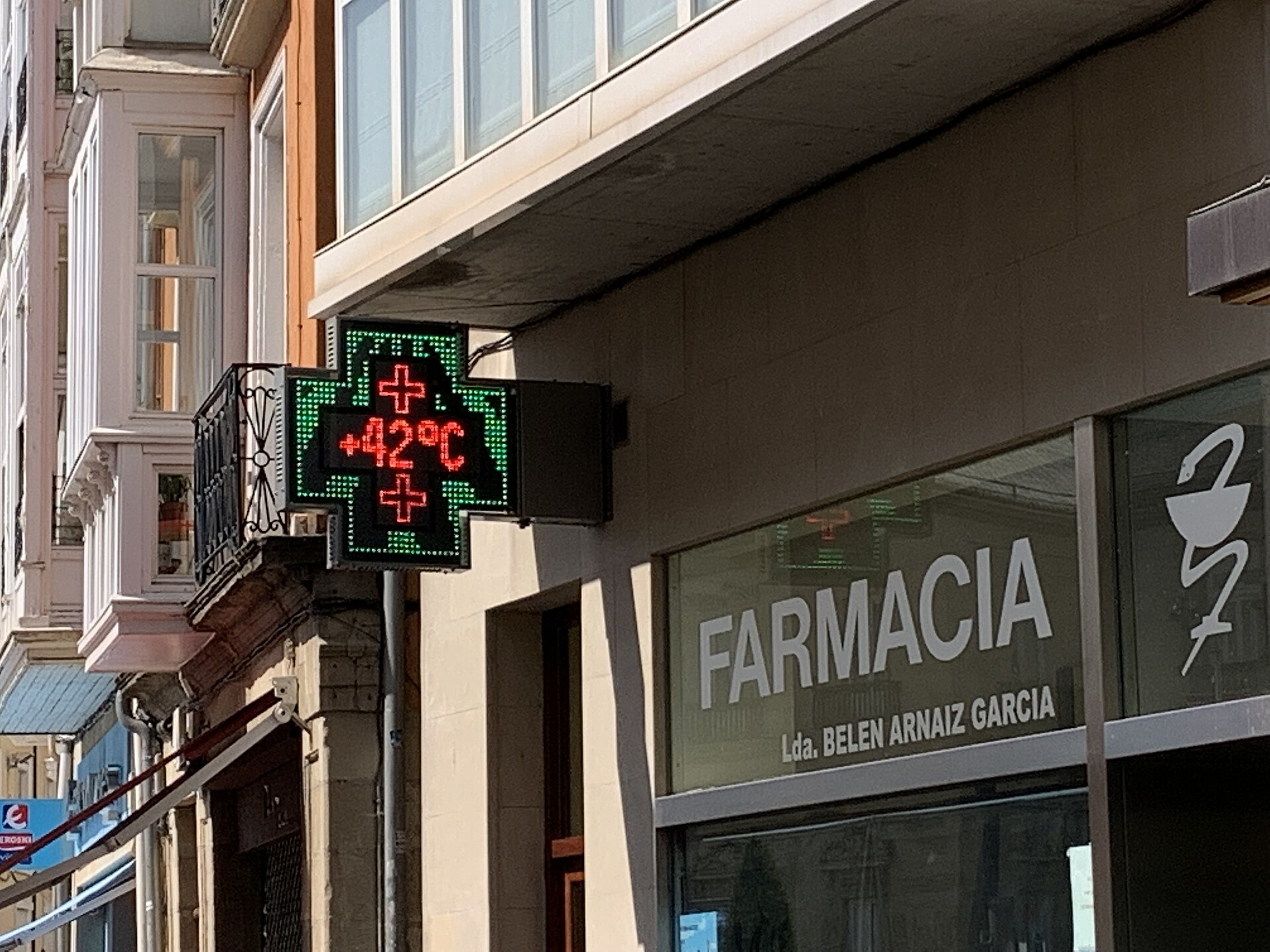 Un rótulo electrónico sobre una farmacia marca 42 °C.