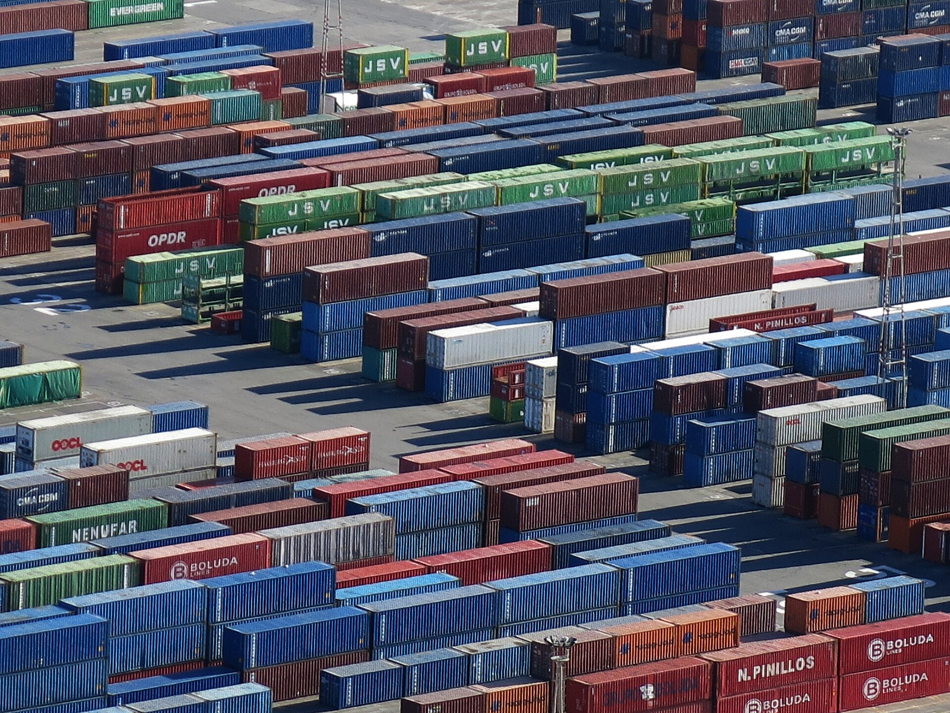 Filas de contenedores de distintos colores apilados en una terminal portuaria.