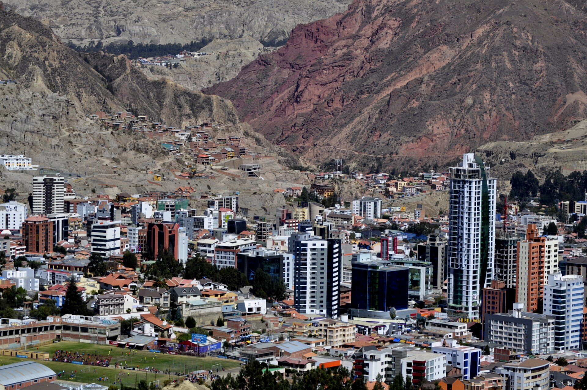 Vista de edificios urbanos al pie de unas montañas rocosas.